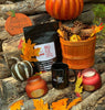 A bag of Inner Peak Coffee sitting in front of a fall themed background featuring pumpkins, pine cones, leaves, and wood.